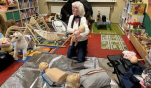 Jutta Pohl in Aktion: Bevor die Teilnehmer beim "Erste Hilfe im Kindernotfall"-Kurs im Familienzentrum Grünheide selber Hand anlegen dürfe, zeigt die Dozentin, wie die richtigen Hangriffe gesetzt werden. Foto: Pauline Thiel