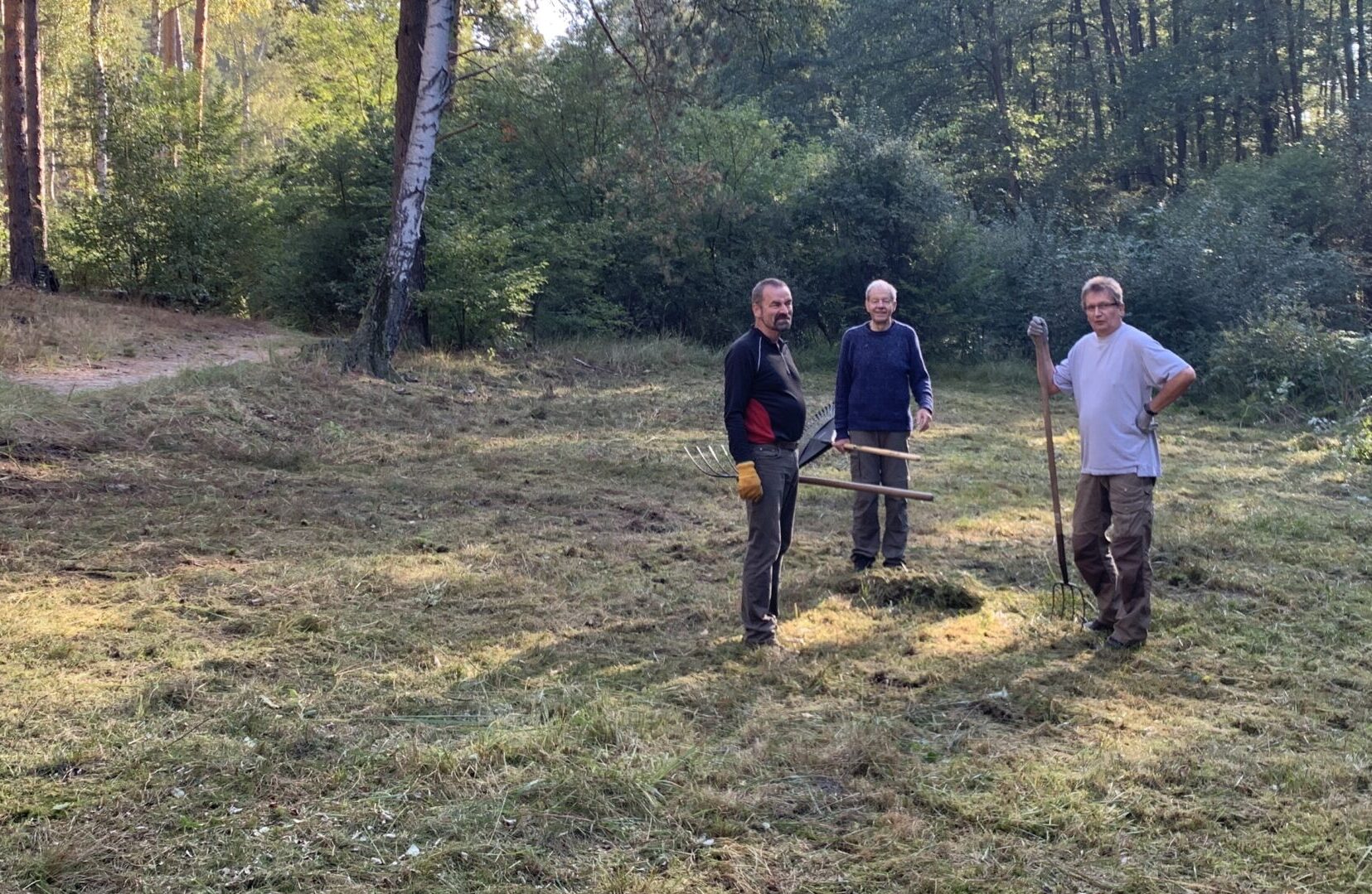 Geschafft: Nach der Mahd muss das Schnittgut zusammengeharkt werden - Peter Weissbach, Bernd Hoyer und Volker Tröster (von links) packen bei den Einsätzen der IG Löcknitztal stets fleißig mit an. Foto: Bernd Ziebarth