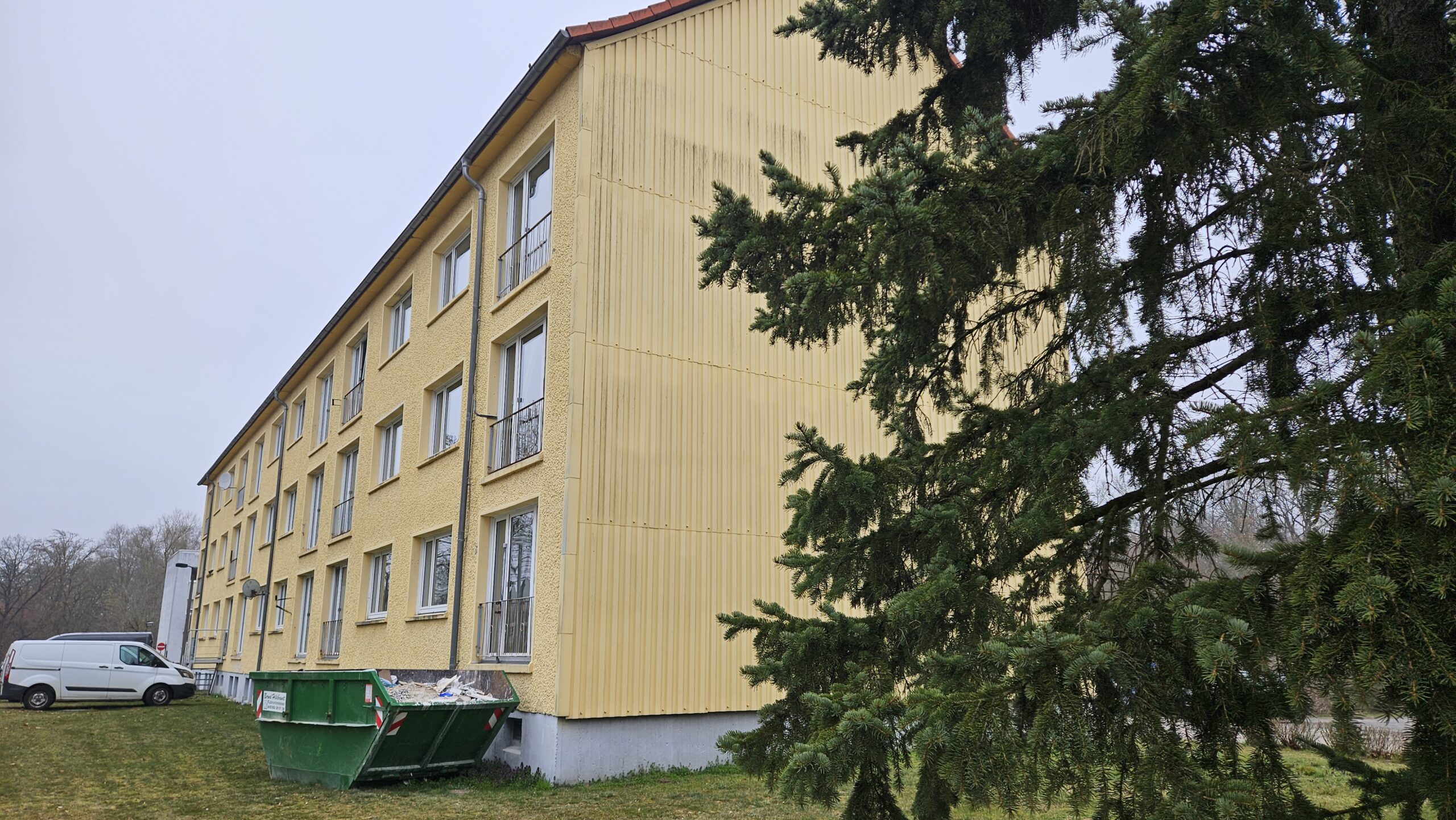 Schuttcontainer vor dem Haus: Die Innen-Sanierung des Wohnblocks ist im vollen Gange. Äußerlich bleibt alles erstmal beim Alten. Foto: Anke Beißer