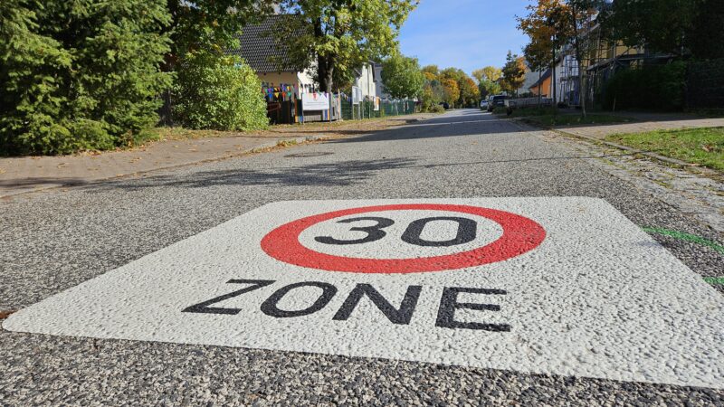 Runter vom Gas!: Tempo-30-Bereiche sind jetzt - wie hier in der Hauptstraße Hangelsberg - mit Markierungen auf der Fahrbahn gekennzeichnet. Foto: Anke Beißer