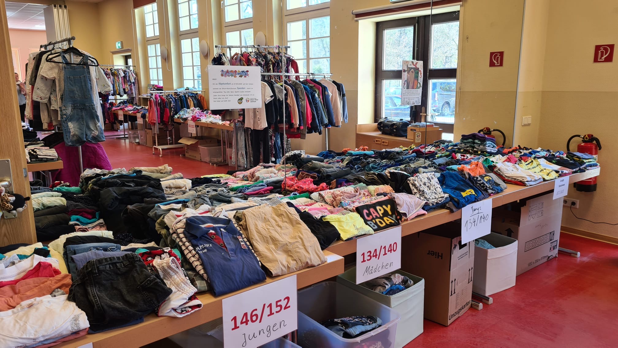 Vorsortiert und zum Mitnehmen bereit: So liebevoll aufgereiht haben die gespendeten Second-Hand-Kleidungsstücke auf die Besucher beim 100%-Flohmarkt auf die Kundschaft im Familienzentrum gewartet. Foto: Heike Falk