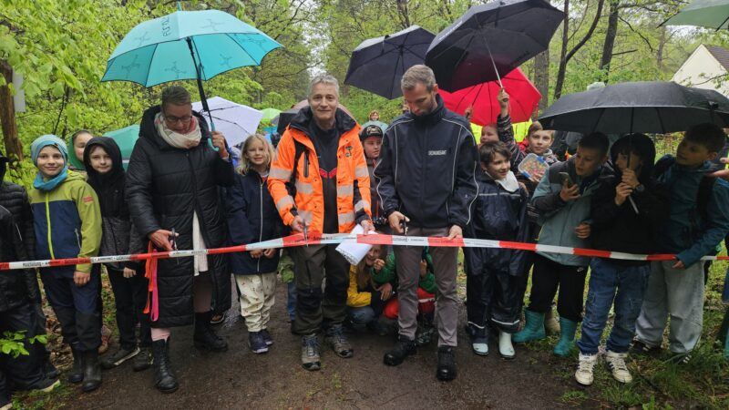 Ganz offiziell eingeweiht: Die Viertklässler der Gerhart-Hauptmann-Grundschule haben am Mittwoch (6. Mai) miterlebt, wie ihre Schulleiterin Sabine Wilde-Balzer, der Leiter des Forstbetriebs Hangelberg Lars Kleinschmidt, sowie Grünheides Ordnungsamtsleiter Nico Bauermeister (von links), das Band durchgeschnitten und den Wanderlehrpfad freigegeben haben. Foto: Anke Beißer