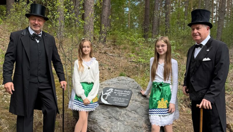 Gedenkstein feierlich enthüllt: Bei der kleinen Zeremonie gesellten sich zu den Grünheider Mädels vom Grünheider Carneval Klub, Lina Rundel (links) und Milla Kucel, Theodor Fontane (dargestellt von Geritt Fiederler, ebenfalls GCK, links) und Gerhart Hauptmann (dargestellt von Hans-Peter Hendriks vom Heimatverein Erkner). Foto: Dorina Rundel