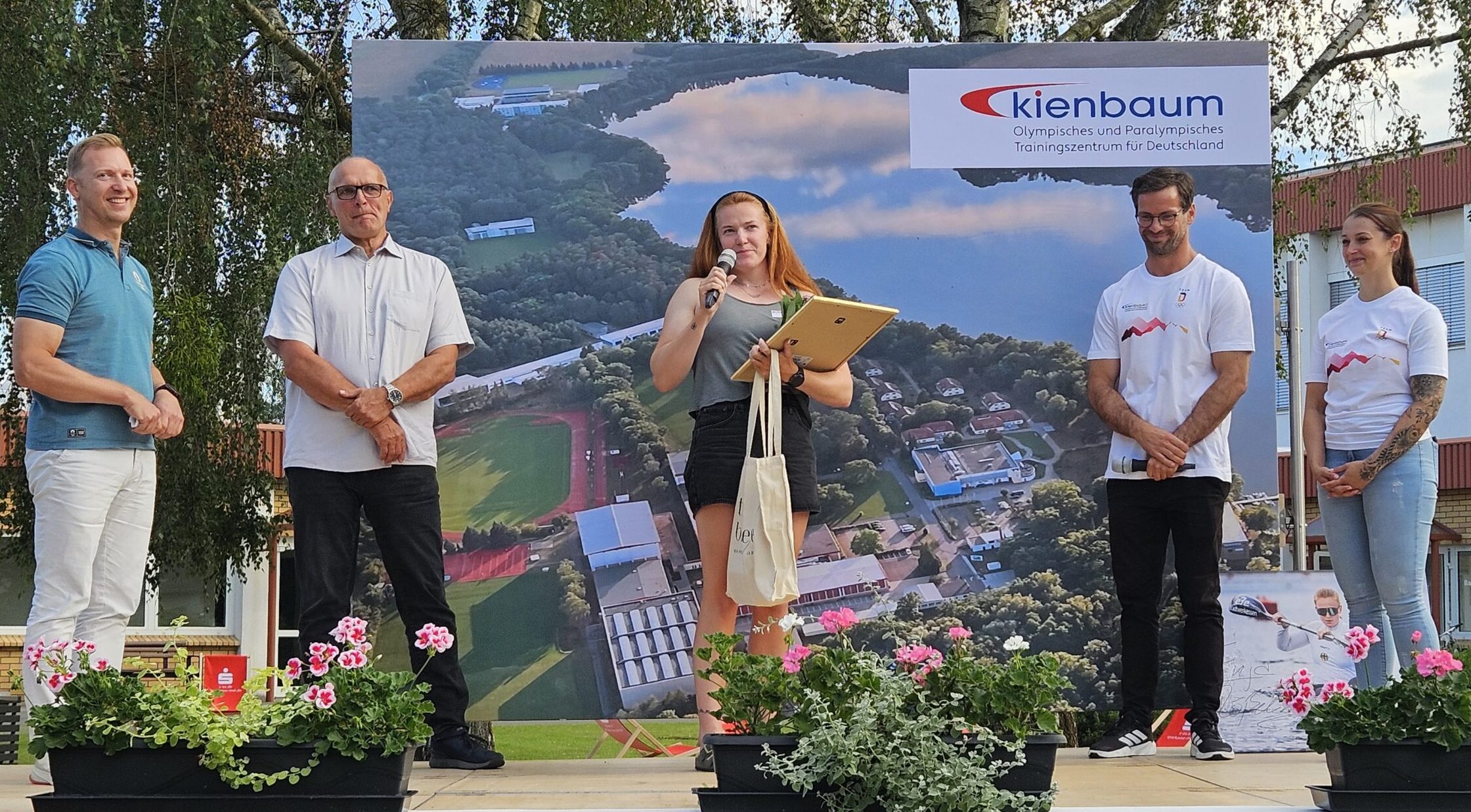 Überraschende Auszeichnung: Kanutin Enja Rößeling (Mitte) durfte sich über den Kienbaum Award 2026 freuen – mit ihr auf der Bühne (von links): Sven Karg (Vorsitzender des Trägervereins), Frank Schlizio (Vorstandsmitglied für Finanzen im Trägerverein), Martin Rieprecht (Geschäftsführer des Trainingszentrums) und Patricia Grafe (Mitarbeiterin Marketing). Foto: Anke Beißer 
