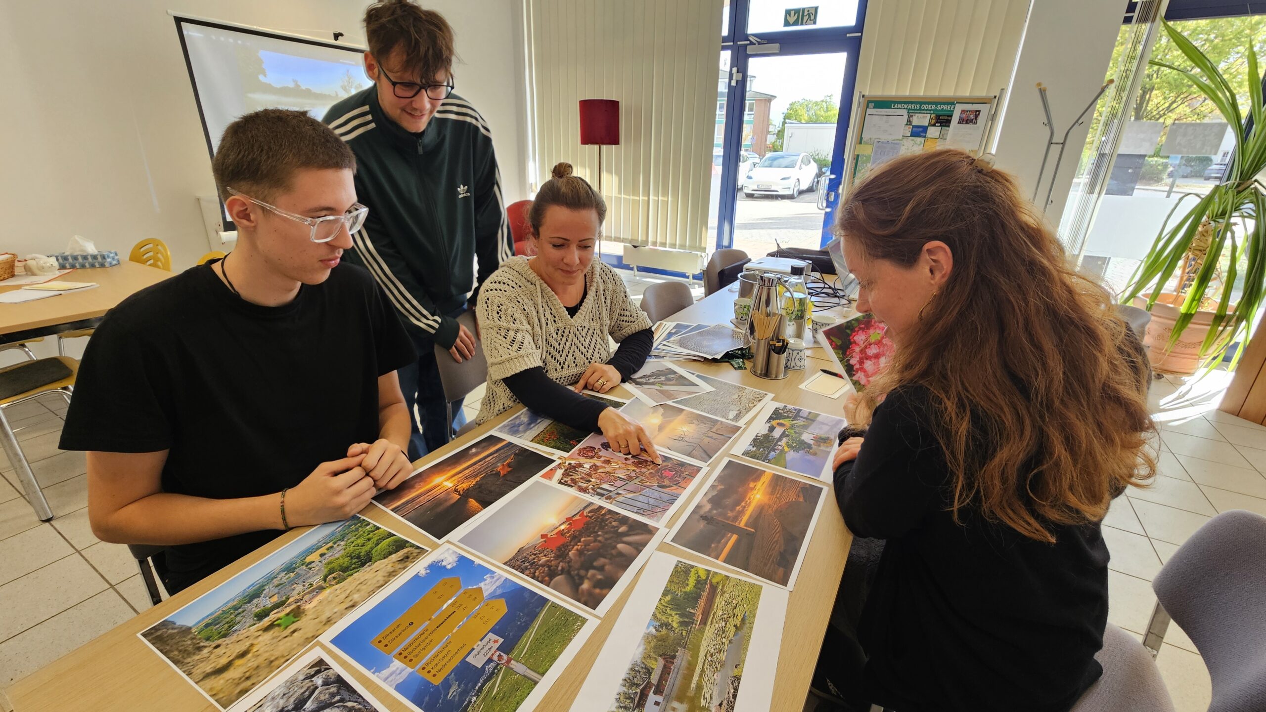 Keine leichte Entscheidung: Ben Rudolph, Bob Braun, Pauline Thiel und Diana Nolander (von links) standen als Jury vor der Qual der Wahl, welches Fotomotiv Eingang in den 2027er-Kalender der Gemeinde Grünheide findet. Foto: Anke Beißer
